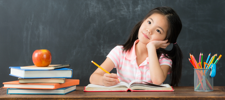 smiling young little girl writing education homework and daydreaming prepare back to school when she studying in blackboard background